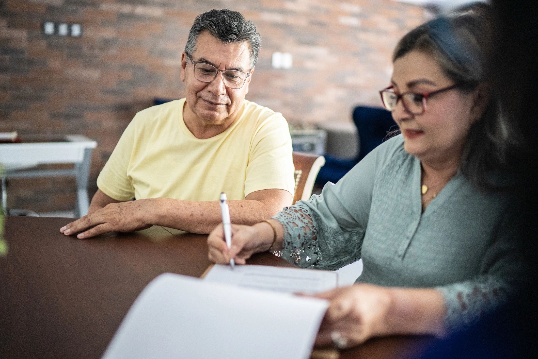 Owners reviewing and signing property paperwork with a professional