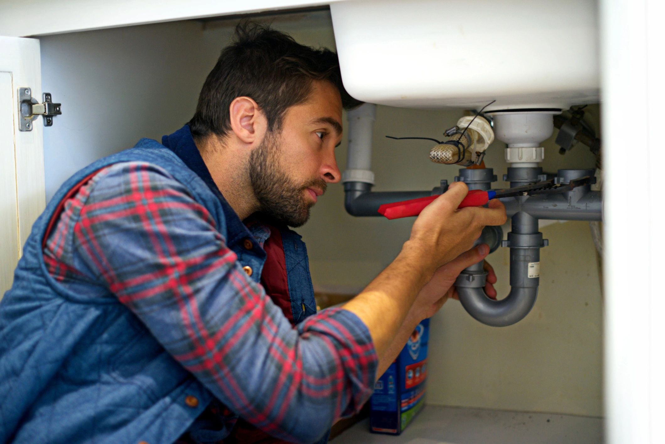 Technician performing plumbing maintenance